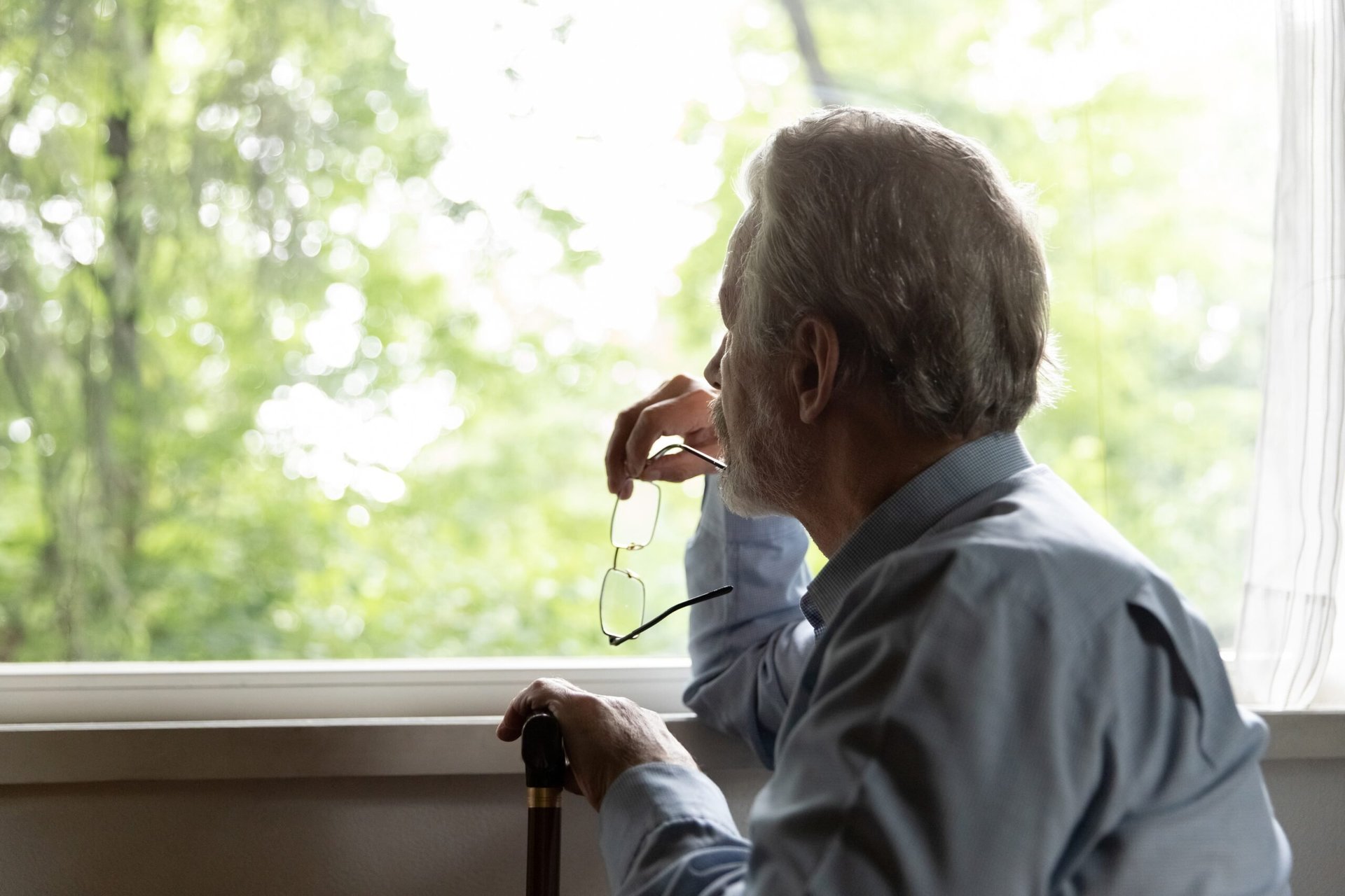 senior man looking out window