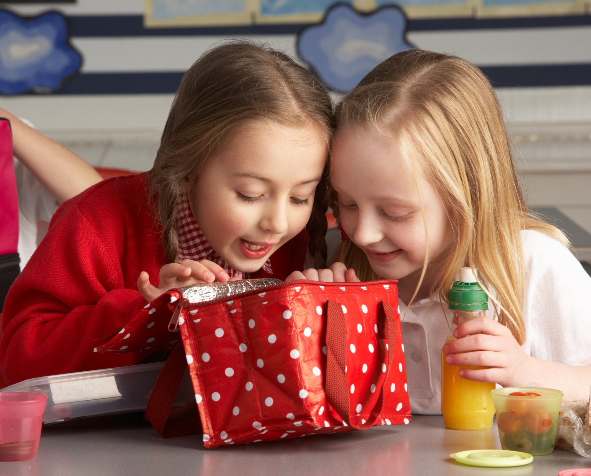 Young girls look into a lunch bag