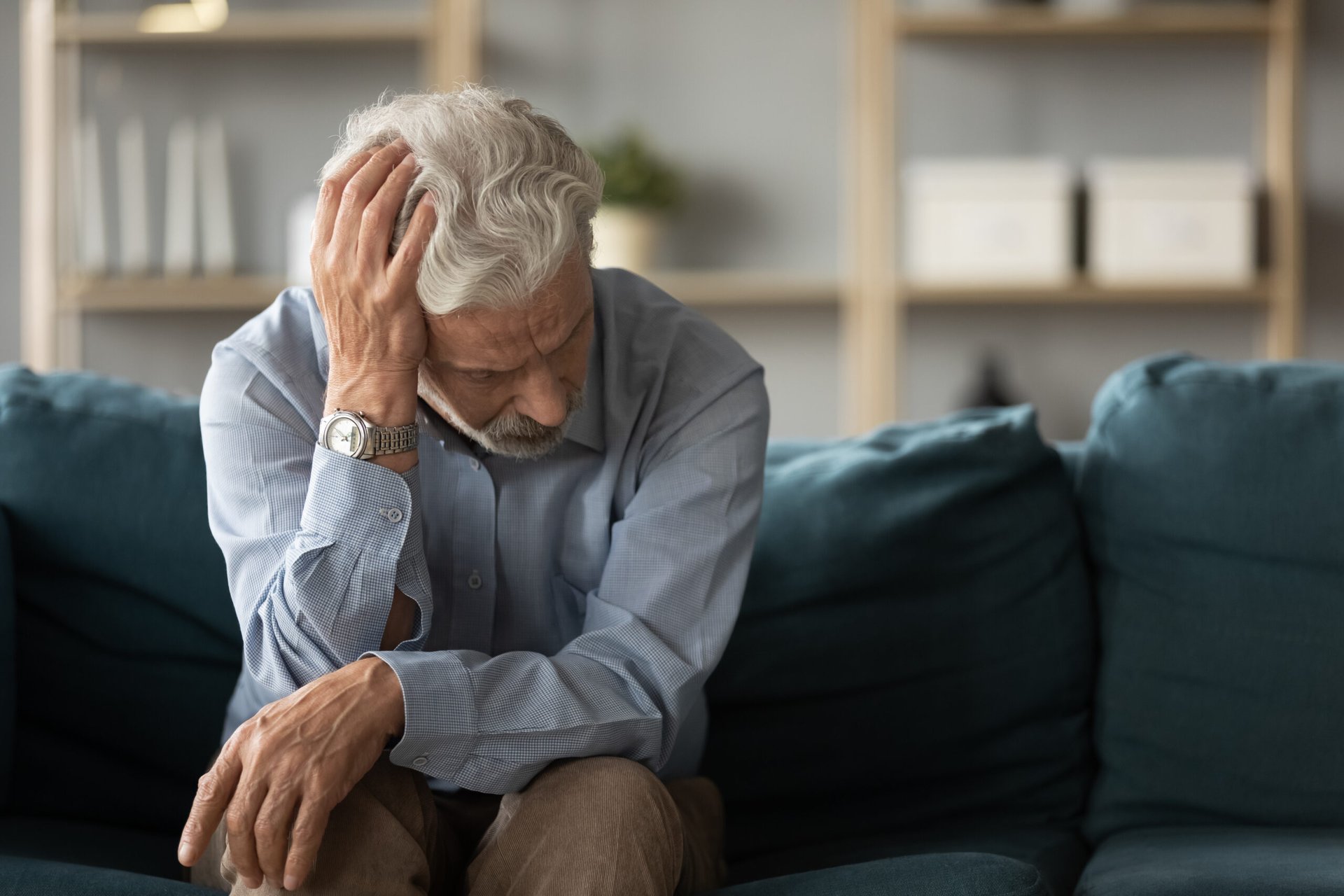 Stressed senior worried and sitting on a couch feeling upset