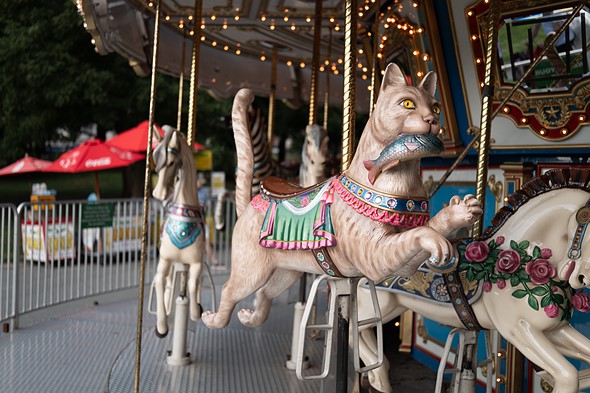 Carousel seat shaped like a cat with a fish in its mouth