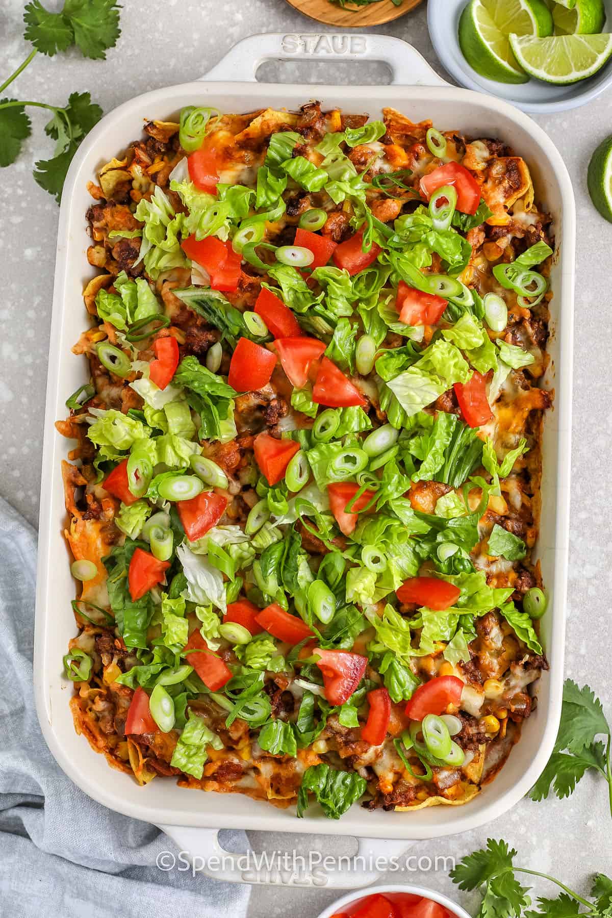 Looking down on a taco bake casserole with lettuce and tomato toppings.